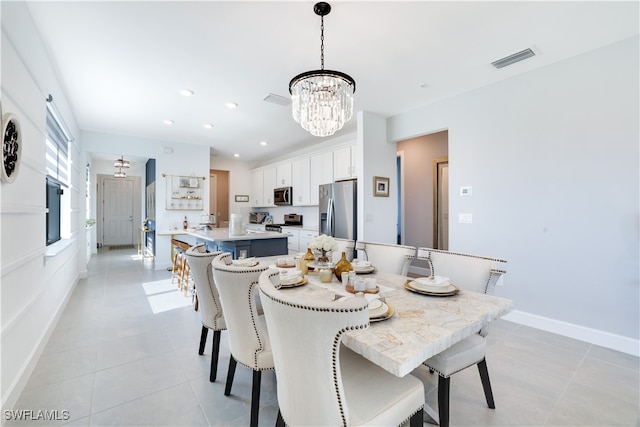 dining area with light tile patterned floors and an inviting chandelier