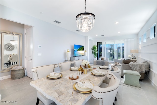 tiled dining area featuring a chandelier