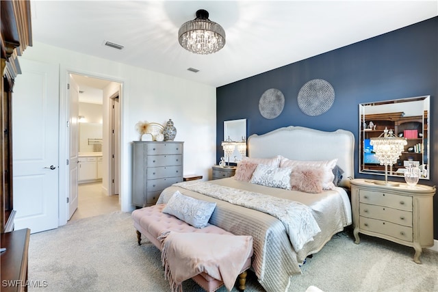 bedroom with ensuite bath, light colored carpet, and an inviting chandelier