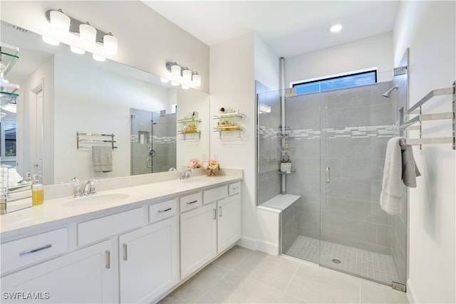 bathroom with tile patterned floors, vanity, and walk in shower