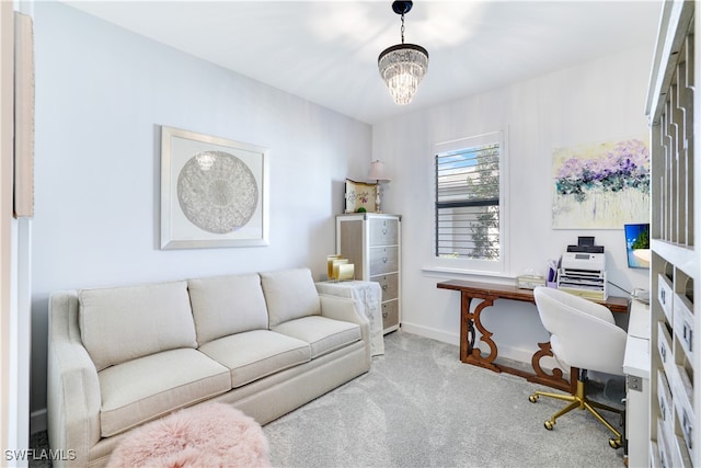 carpeted home office featuring a chandelier