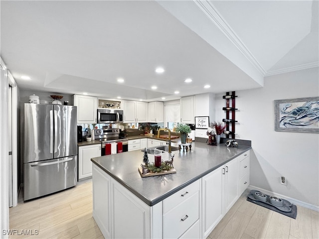 kitchen featuring kitchen peninsula, white cabinetry, sink, and stainless steel appliances