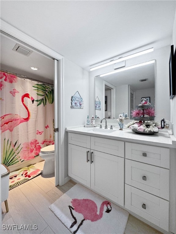 bathroom with hardwood / wood-style flooring, vanity, and toilet