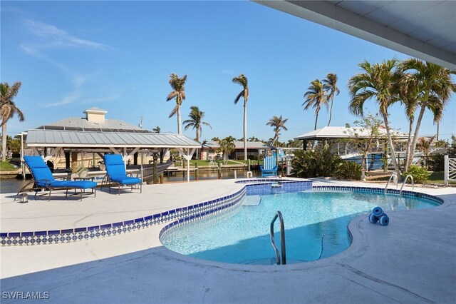 view of pool with a patio area and a water view