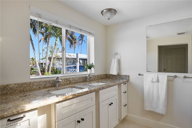 bathroom with tile patterned floors, vanity, and a textured ceiling