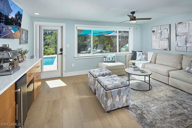 living room featuring ceiling fan and light wood-type flooring