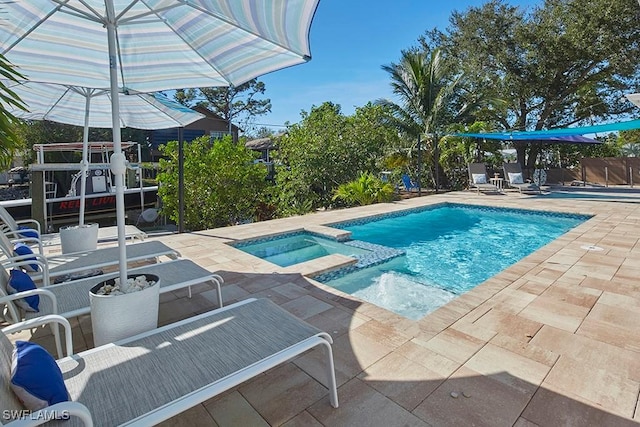 view of swimming pool with a patio area and an in ground hot tub