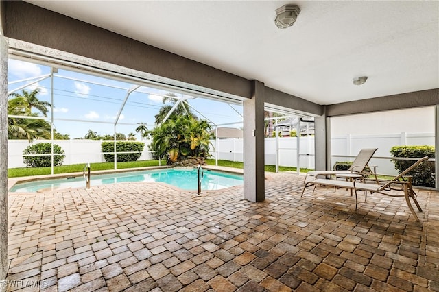 view of pool featuring glass enclosure and a patio