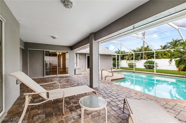 view of pool featuring glass enclosure and a patio area