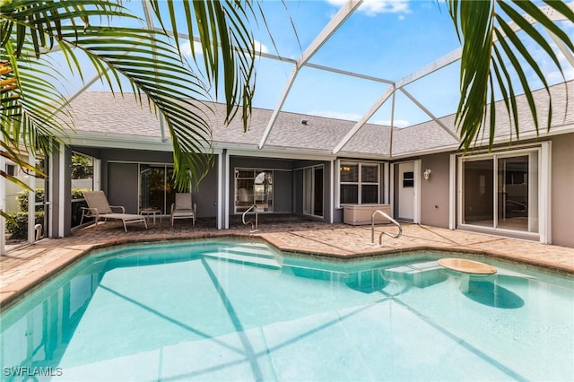 view of swimming pool with glass enclosure and a patio area