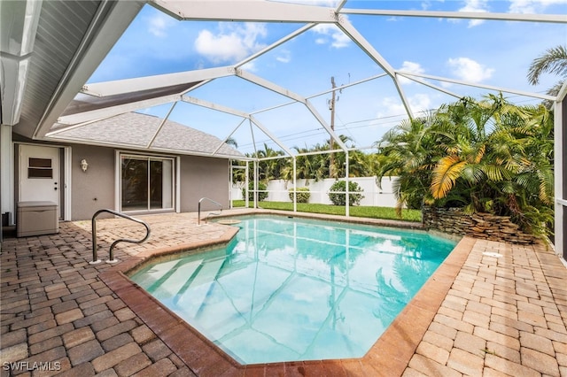 view of swimming pool featuring a patio and glass enclosure