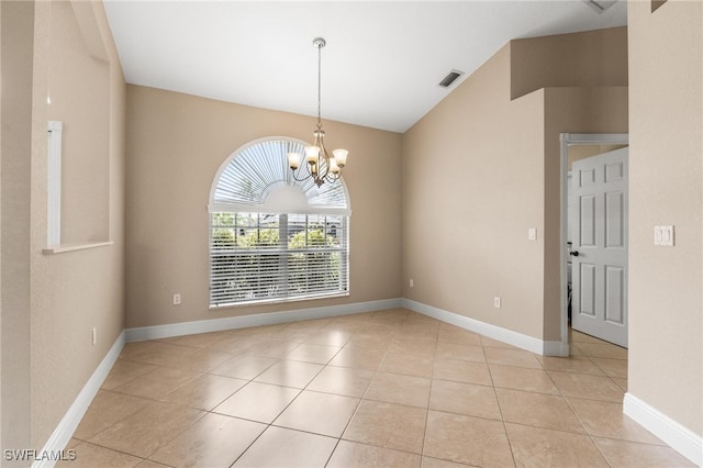 spare room with a chandelier and light tile patterned floors