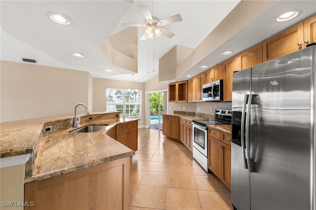 kitchen with sink, light stone counters, light tile patterned floors, ceiling fan with notable chandelier, and appliances with stainless steel finishes