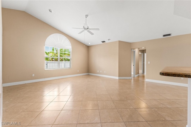 tiled empty room featuring ceiling fan and lofted ceiling