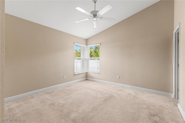 spare room with ceiling fan, light colored carpet, and vaulted ceiling