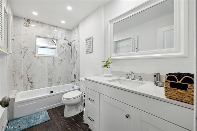 full bathroom with hardwood / wood-style floors, tiled shower / bath combo, toilet, and vanity