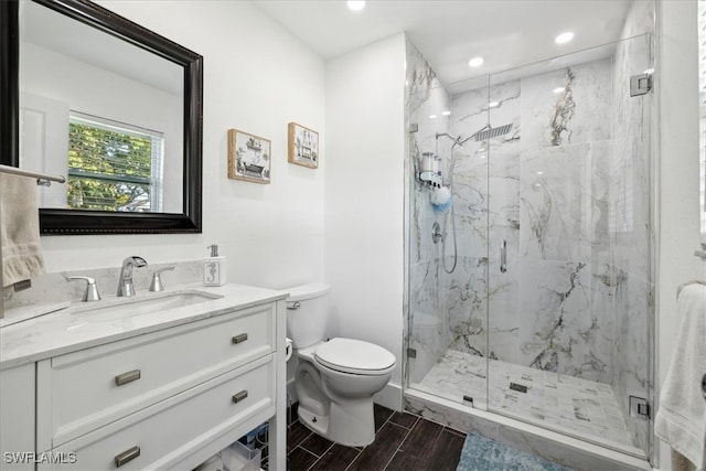 bathroom featuring vanity, toilet, and a shower with shower door