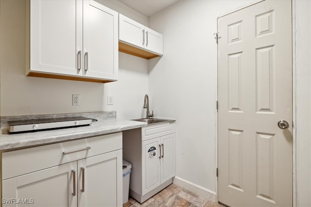 kitchen featuring sink and white cabinets