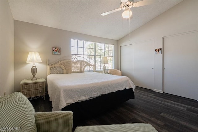 bedroom with a textured ceiling, dark hardwood / wood-style floors, vaulted ceiling, and ceiling fan