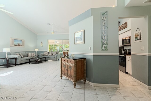 living area with light tile patterned floors, ceiling fan, high vaulted ceiling, baseboards, and ornamental molding