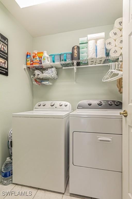 washroom featuring laundry area, light tile patterned floors, and washing machine and clothes dryer