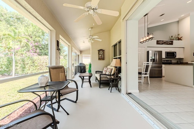 sunroom with vaulted ceiling and a ceiling fan