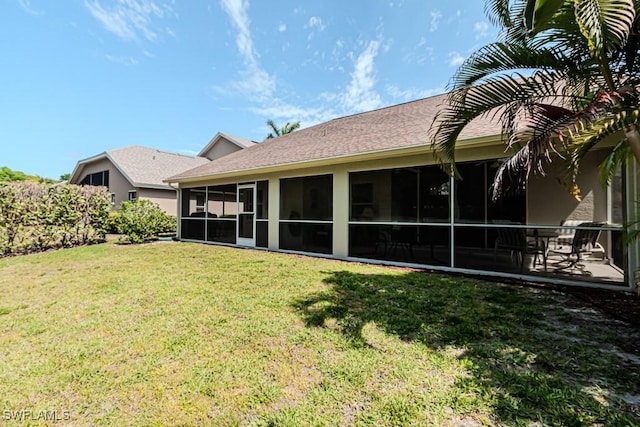 rear view of property with a sunroom and a yard