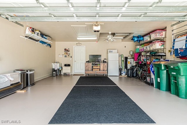 garage with a garage door opener, freestanding refrigerator, and ceiling fan