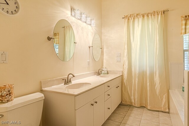 full bathroom featuring toilet, tile patterned flooring, double vanity, and a sink