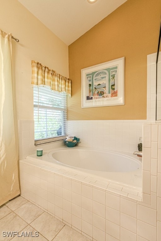 full bath with vaulted ceiling, a bath, and tile patterned floors