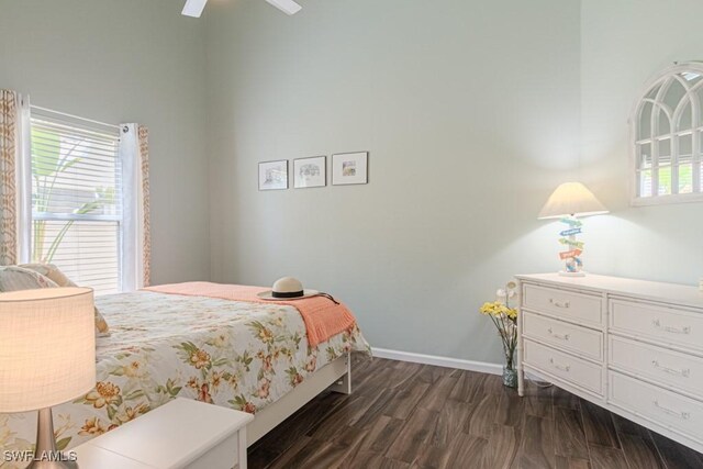 bedroom with a ceiling fan, dark wood finished floors, and baseboards