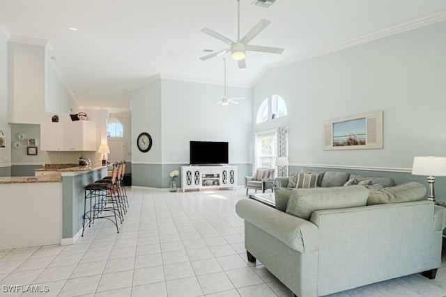 living room with crown molding, light tile patterned floors, visible vents, a ceiling fan, and high vaulted ceiling