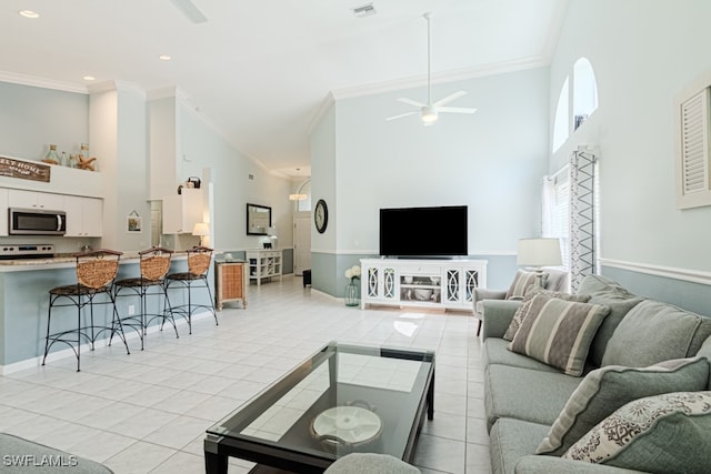 living area featuring ornamental molding, visible vents, a towering ceiling, and light tile patterned floors