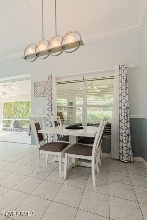 dining space with ornamental molding, ceiling fan, baseboards, and light tile patterned floors