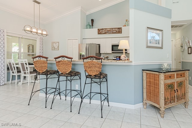 kitchen with crown molding, visible vents, hanging light fixtures, appliances with stainless steel finishes, and white cabinetry