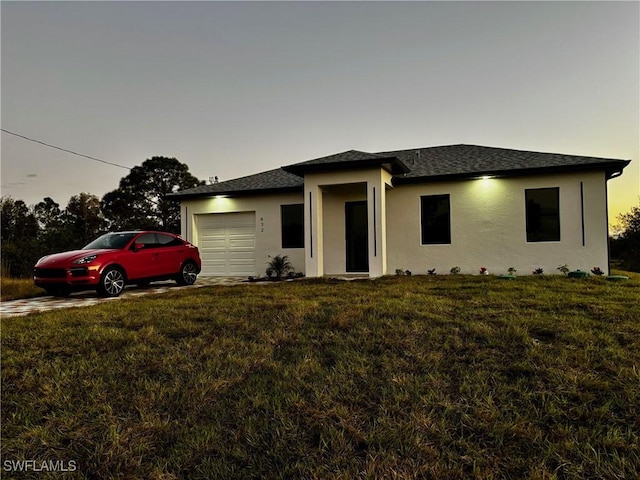 view of front of property with a garage and a lawn