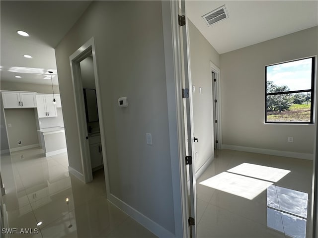 corridor featuring light tile patterned floors