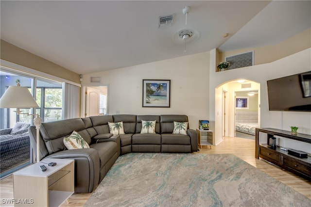 living room with lofted ceiling, ceiling fan, and light wood-type flooring