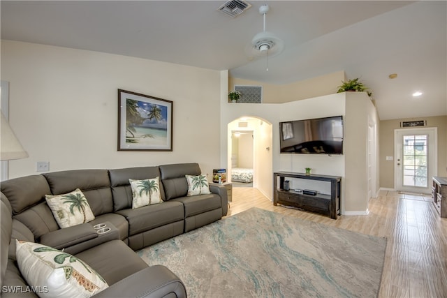 living room featuring vaulted ceiling, light hardwood / wood-style flooring, and ceiling fan