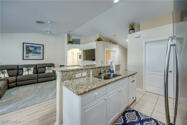 kitchen with white cabinetry, sink, an island with sink, and vaulted ceiling