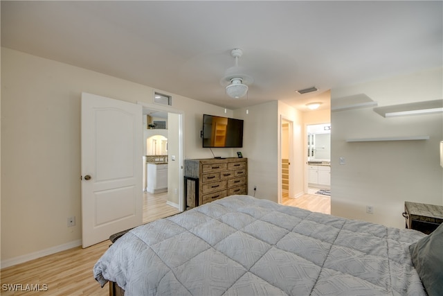 bedroom featuring ceiling fan, connected bathroom, and light hardwood / wood-style flooring