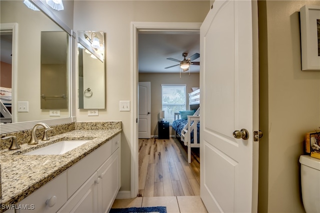 bathroom with ceiling fan, toilet, wood-type flooring, and vanity