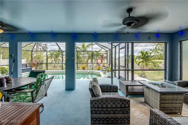 sunroom with ceiling fan, a pool, and a wealth of natural light