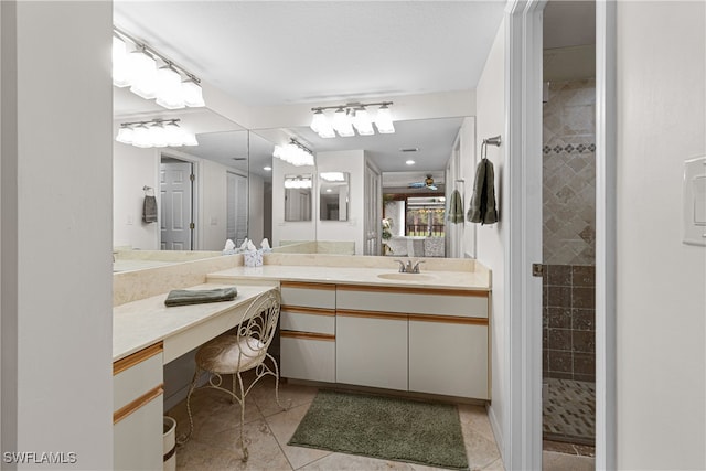 bathroom featuring tile patterned flooring, vanity, and tiled shower