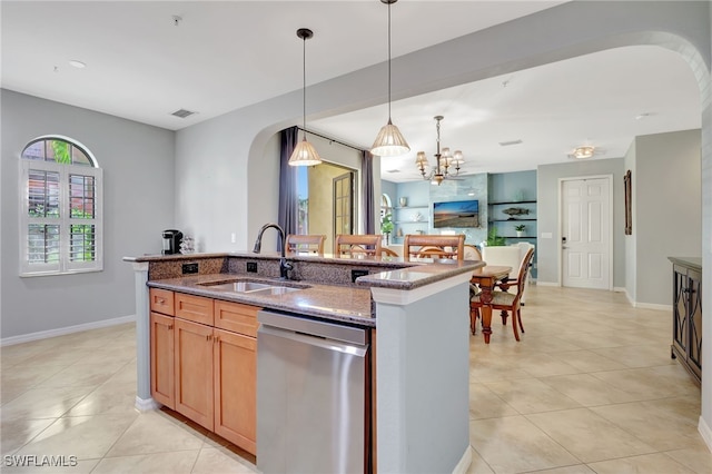 kitchen featuring dishwasher, light stone counters, sink, and a kitchen island with sink