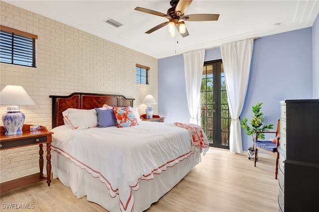 bedroom featuring access to exterior, ceiling fan, brick wall, crown molding, and light wood-type flooring