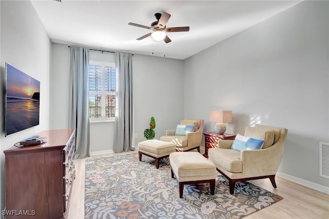 sitting room with ceiling fan and light hardwood / wood-style flooring