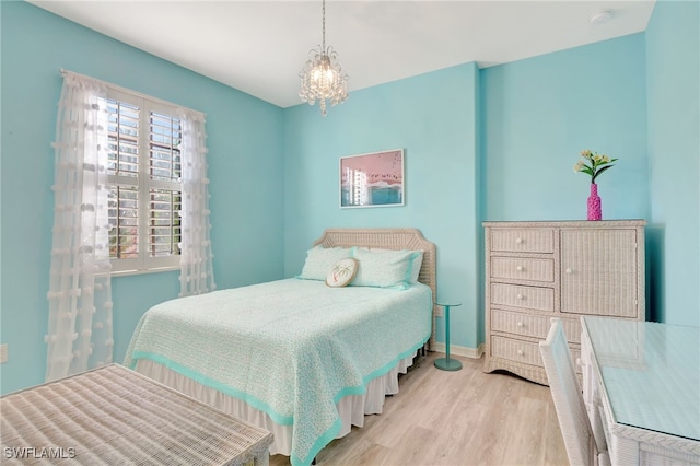 bedroom featuring light hardwood / wood-style floors and a notable chandelier