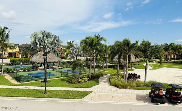 surrounding community with a yard and tennis court