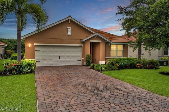 view of front of house with a garage and a lawn